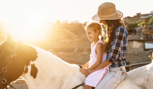 texas-horses Happy family with mother and daughter on a horse on a farm in Texas, USA